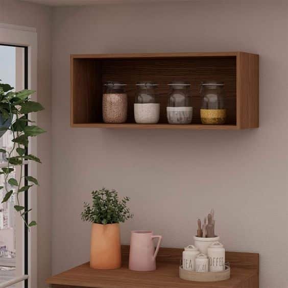 13. O nicho para cozinha de madeira acrescenta sofisticação e elegância ao ambiente. A decoração pode ser feita com os próprios utensílios, como taças de vinho e peças mais coloridas para dar mais frescor ao ambiente.