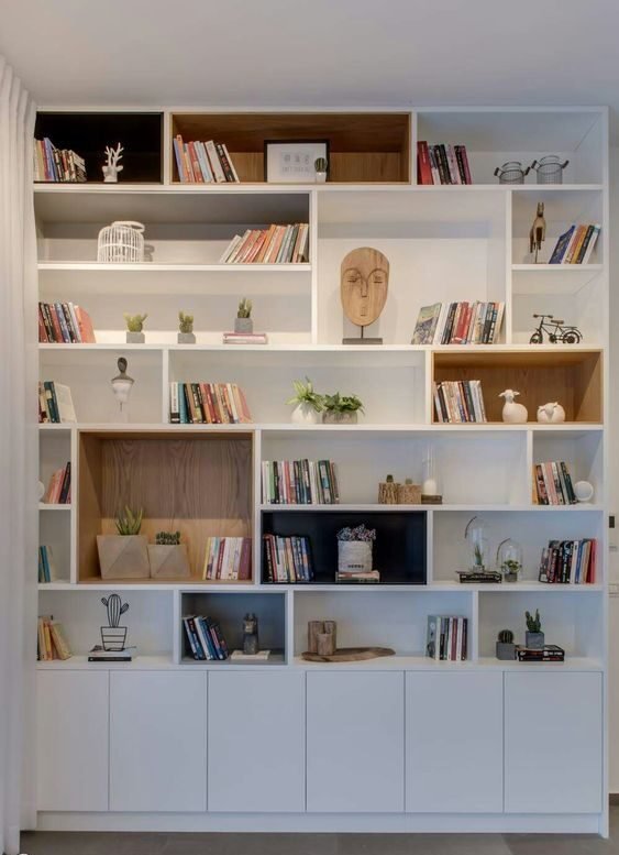 Nessa imagem, vemos bem como uma estante pode ser organizada para termos uma biblioteca e ao mesmo tempo incluir elementos decorativos, gerando ligação e harmonia entre os itens.