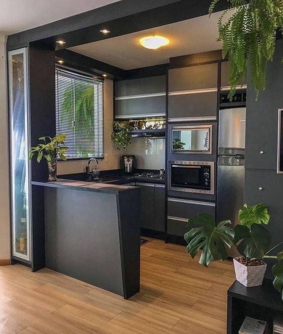 Já nas cozinhas pequenas, uma forma de evitar isso utilizando seus armários pretos é deixando um espaço aberto, já que a colocação de portas reduziria ainda mais a extensão da cozinha visualmente.