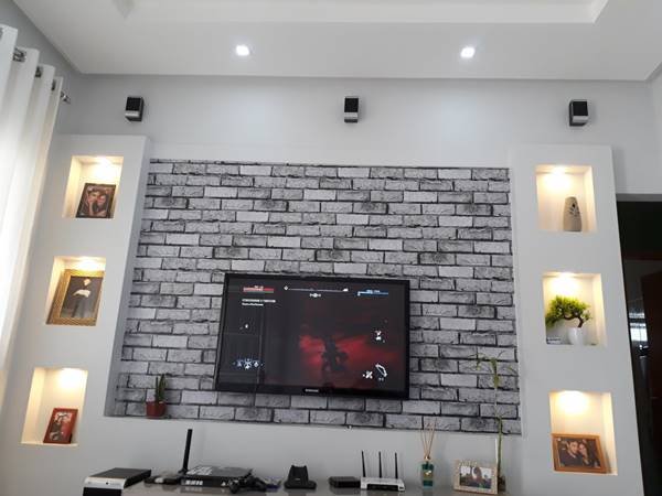 Na sala, a parede de gesso suporta painel de TV e serve como uma base decorativa.