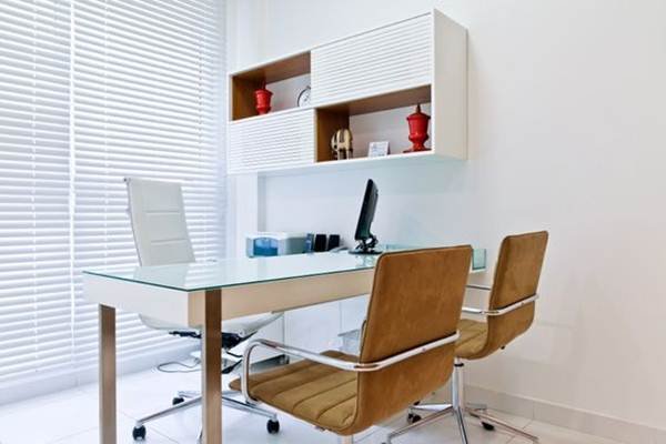 Decoração mais enxuta e neutra com cadeiras brancas e caramelo, persianas brancas e armário suspenso.