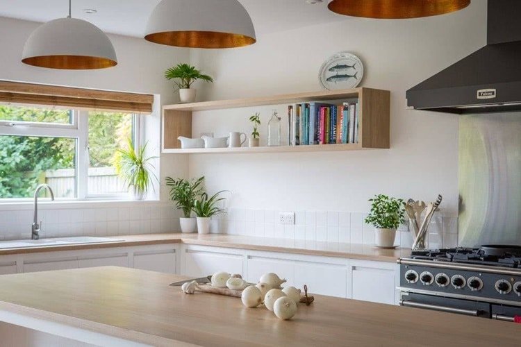 1. Um só nicho na cozinha pode fazer a diferença na decoração. O nicho de madeira retangular acima da bancada recebe objetos decorativos.